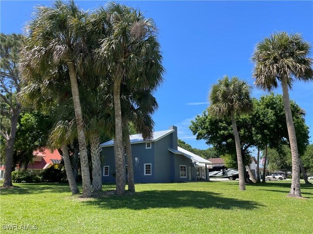 200 Ridgewood Ave, Clewiston, FL 33440 - view of side of property featuring a lawn and stucco siding