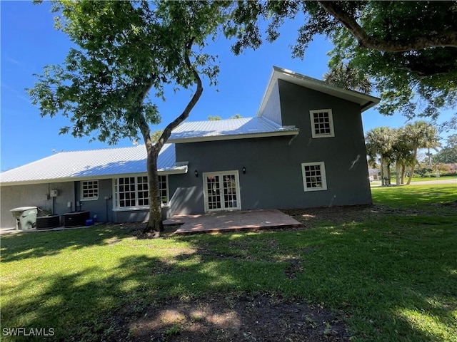 back of house with central AC unit, a lawn, french doors, and a patio area