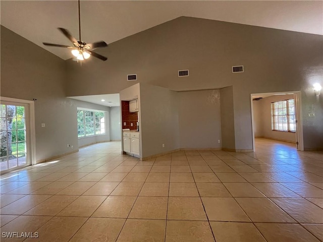 unfurnished living room featuring light tile patterned flooring, ceiling fan, and high vaulted ceiling