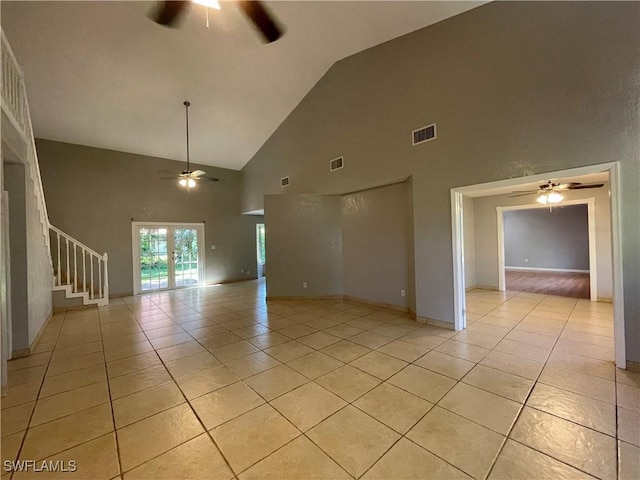 empty room with lofted ceiling, french doors, ceiling fan, and light tile patterned flooring