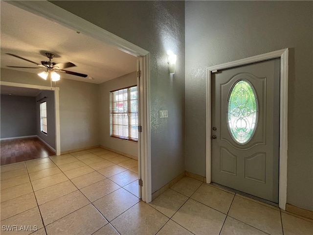 tiled entryway featuring ceiling fan