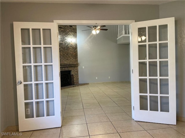 unfurnished living room with light tile patterned flooring, ceiling fan, and a fireplace