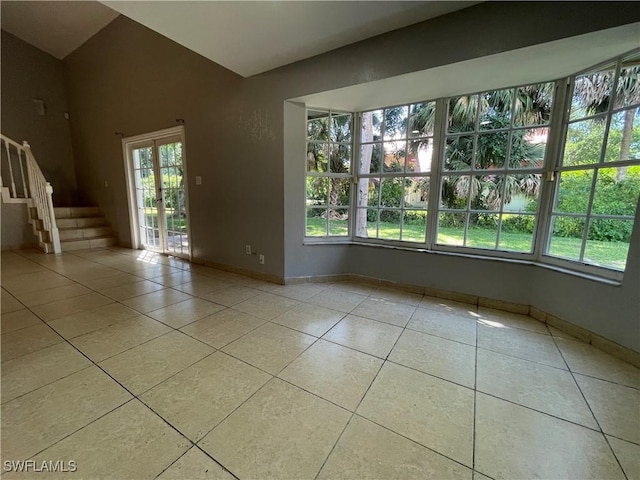 tiled spare room with french doors and vaulted ceiling