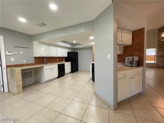 kitchen featuring tasteful backsplash, black appliances, white cabinets, light tile patterned floors, and a tray ceiling