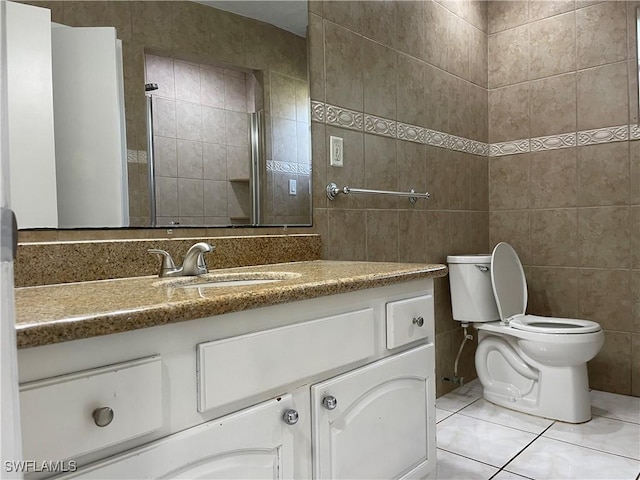 bathroom with tile patterned floors, vanity, toilet, and tile walls