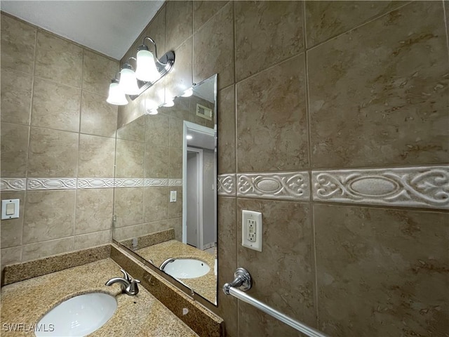 bathroom with tile walls, vanity, and backsplash