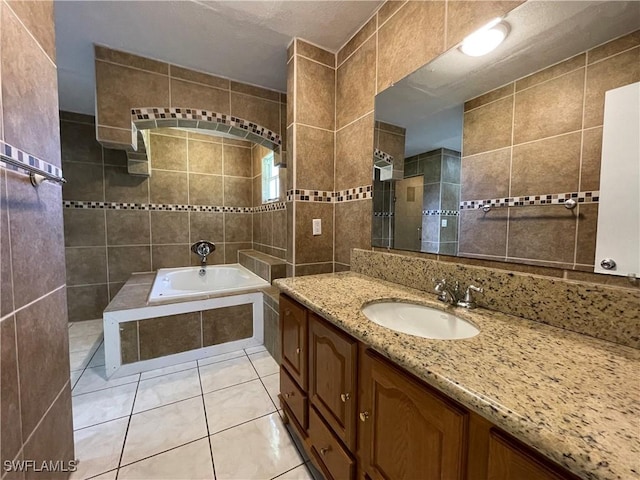 bathroom with tile walls, vanity, tile patterned floors, and independent shower and bath