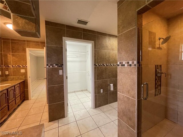 200 Ridgewood Ave, Clewiston, FL 33440 - full bath featuring tile walls, a shower stall, tile patterned flooring, vanity, and a walk in closet