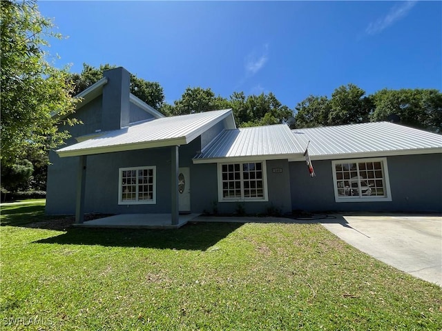 200 Ridgewood Ave, Clewiston, FL 33440 - view of front of property with stucco siding, a front lawn, metal roof, and a patio
