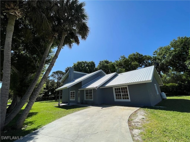 200 Ridgewood Ave, Clewiston, FL 33440 - ranch-style home with driveway, a front lawn, metal roof, and stucco siding