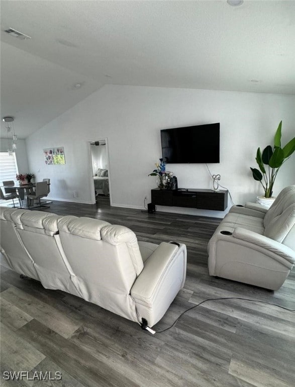 living room featuring dark wood-type flooring and vaulted ceiling