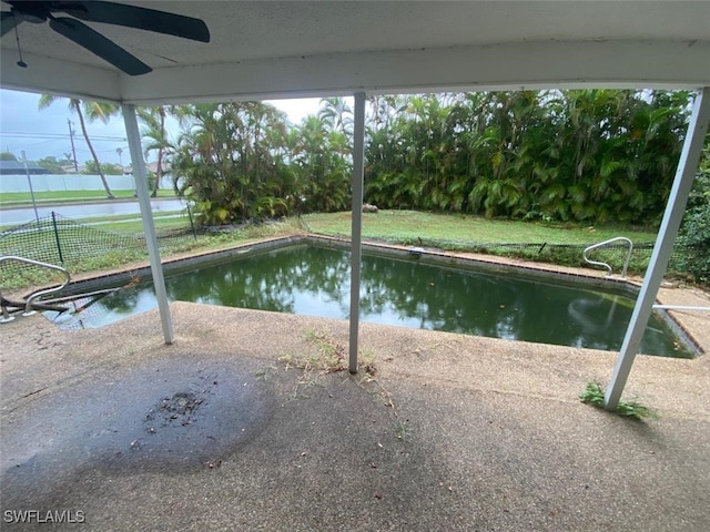 view of pool featuring a patio, ceiling fan, and a water view