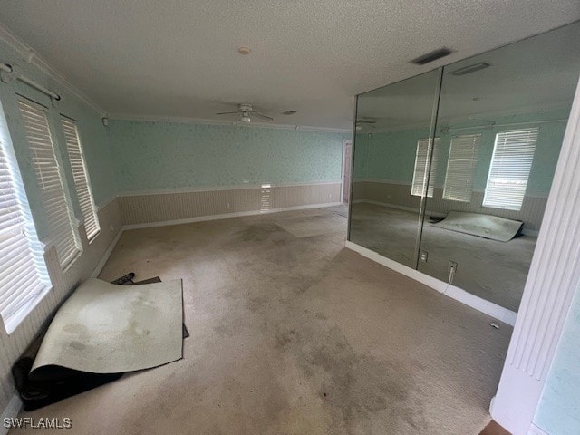 bathroom with ceiling fan, ornamental molding, and a textured ceiling