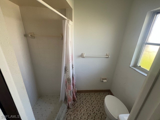 bathroom featuring curtained shower and toilet