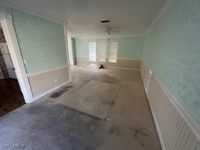 empty room with crown molding, light colored carpet, and ceiling fan