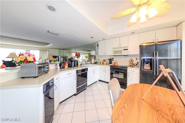 kitchen featuring white cabinets, a wealth of natural light, light tile patterned floors, and black appliances