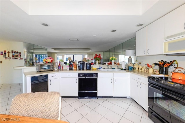 kitchen with sink, white cabinetry, light tile patterned floors, kitchen peninsula, and black appliances