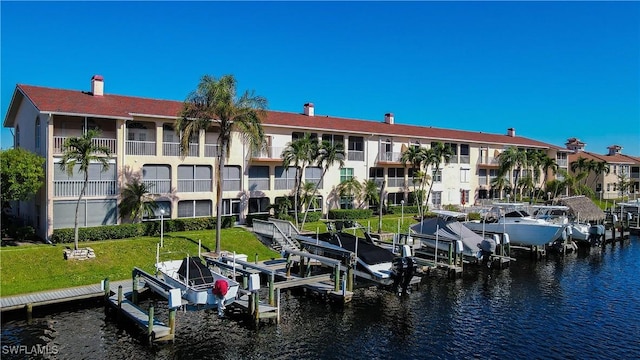 view of dock with a water view and a yard