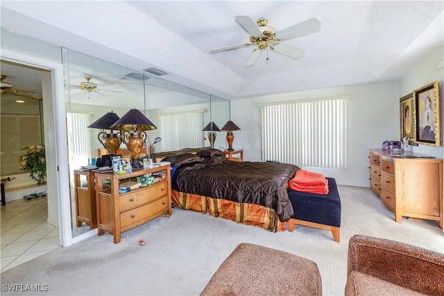 carpeted bedroom with a raised ceiling and ceiling fan