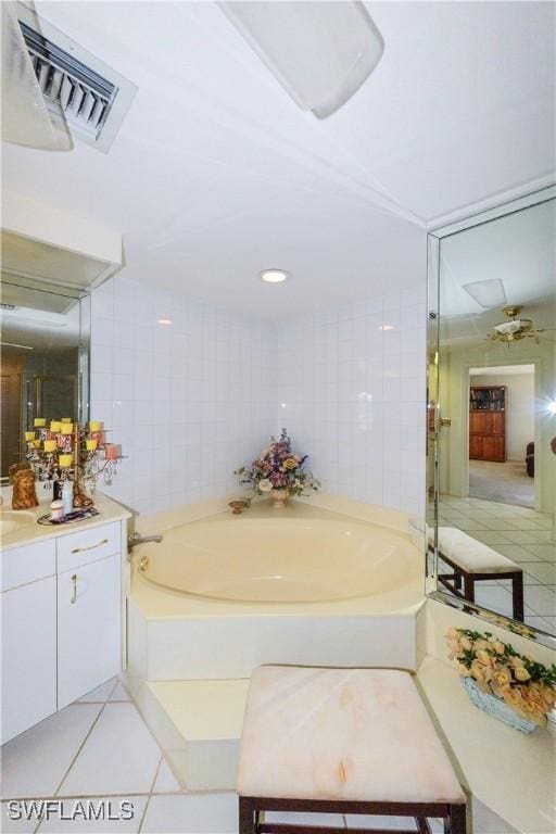 bathroom featuring tile walls, a tub to relax in, tile patterned flooring, and vanity