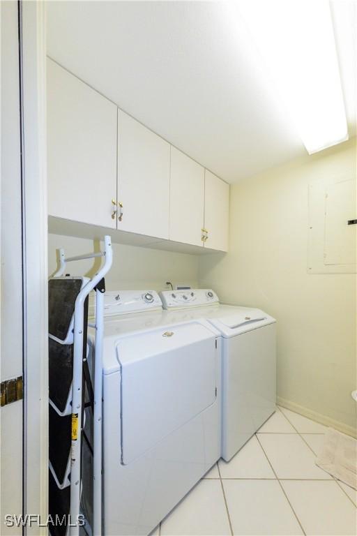 laundry room with independent washer and dryer, light tile patterned floors, and cabinets