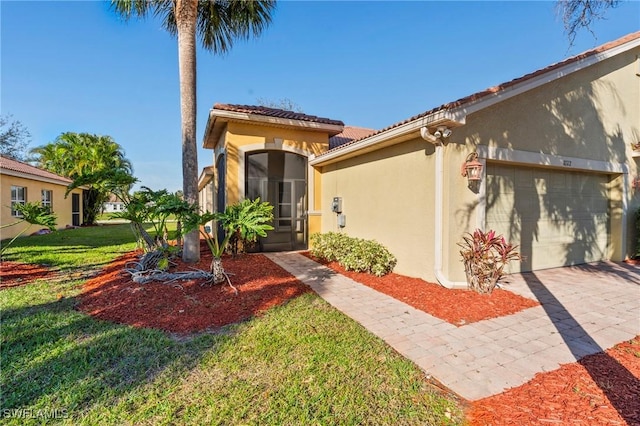 mediterranean / spanish house featuring a garage and a front yard