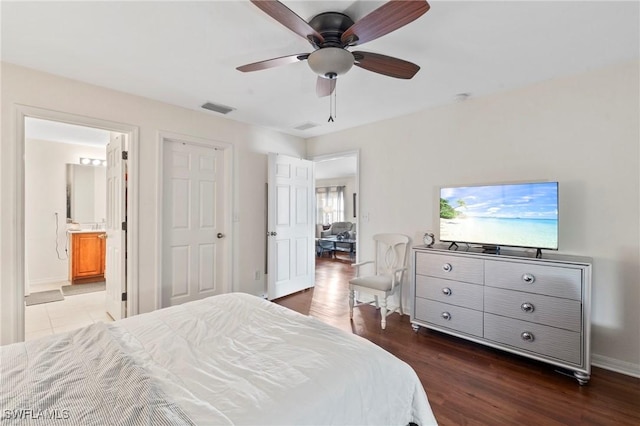 bedroom with ensuite bath, dark wood-type flooring, and ceiling fan