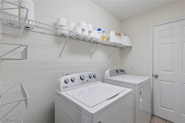 washroom with light tile patterned flooring and washer and dryer