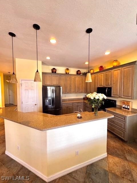 kitchen with stove, a textured ceiling, stainless steel fridge with ice dispenser, decorative light fixtures, and a large island with sink