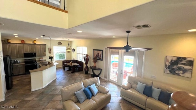 living room featuring french doors, ceiling fan, and sink