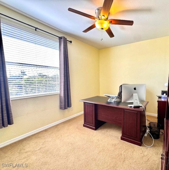 carpeted home office featuring ceiling fan