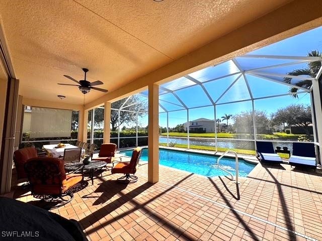 view of pool with an outdoor living space, a lanai, a patio, and a water view