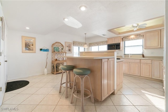 kitchen with light tile patterned flooring, hanging light fixtures, a center island, plenty of natural light, and light brown cabinets