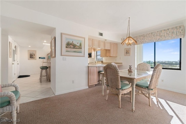 carpeted dining space with a chandelier