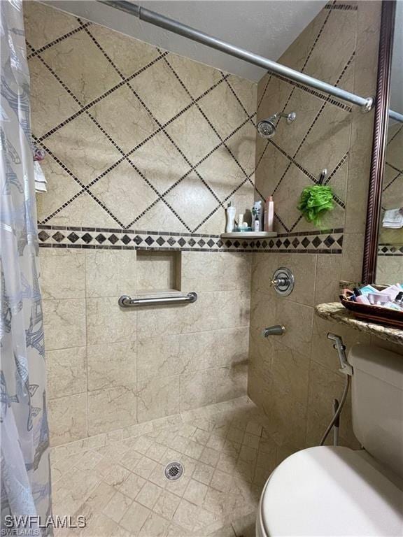 bathroom with curtained shower and toilet