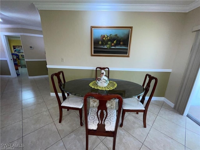 tiled dining room featuring ornamental molding