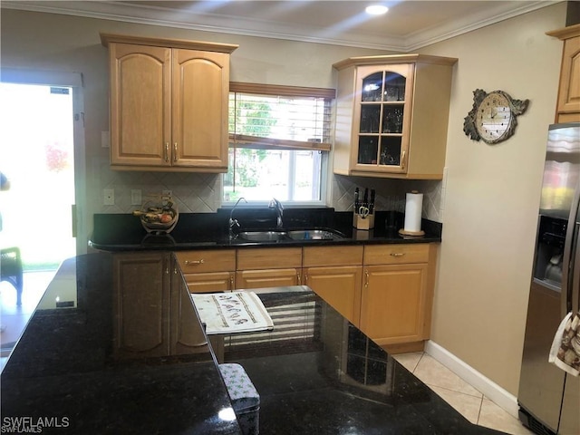 kitchen with light tile patterned flooring, sink, backsplash, stainless steel fridge, and ornamental molding