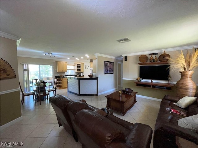 living room with ornamental molding and light tile patterned floors