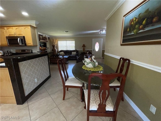 tiled dining room featuring crown molding