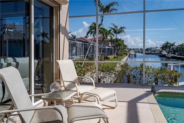 exterior space with glass enclosure and a water view