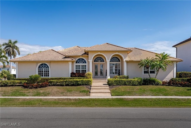 mediterranean / spanish-style house with french doors and a front yard