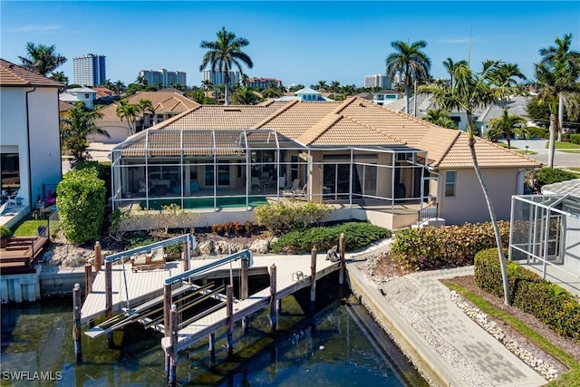 rear view of house featuring a lanai and a water view