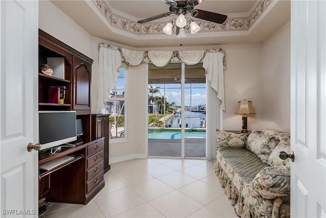 sitting room featuring ornamental molding, a raised ceiling, ceiling fan, and light tile patterned flooring