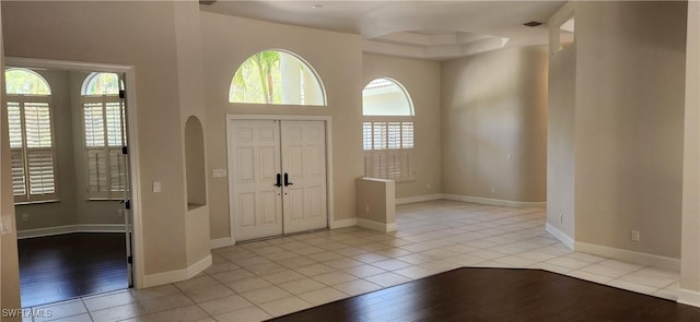 tiled entrance foyer featuring a towering ceiling