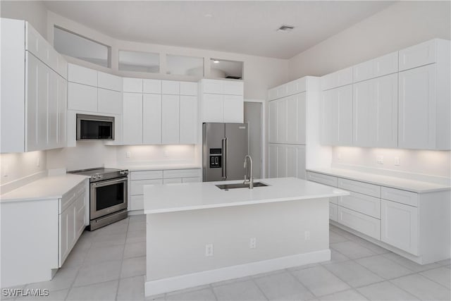 kitchen with an island with sink, appliances with stainless steel finishes, sink, and white cabinets