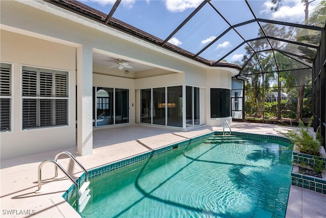 view of pool with ceiling fan, a patio area, and glass enclosure