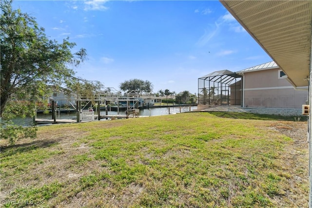 view of yard with a water view and glass enclosure