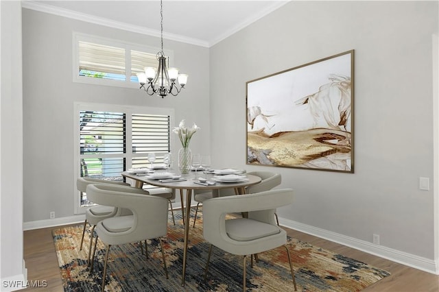 dining room with hardwood / wood-style flooring, crown molding, and an inviting chandelier