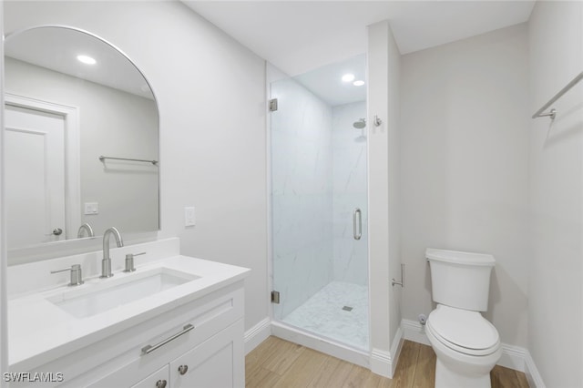 bathroom with hardwood / wood-style flooring, vanity, toilet, and an enclosed shower