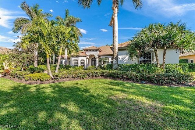 mediterranean / spanish home with a front yard